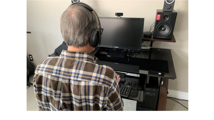 Blind man working at a computer as seen from behind